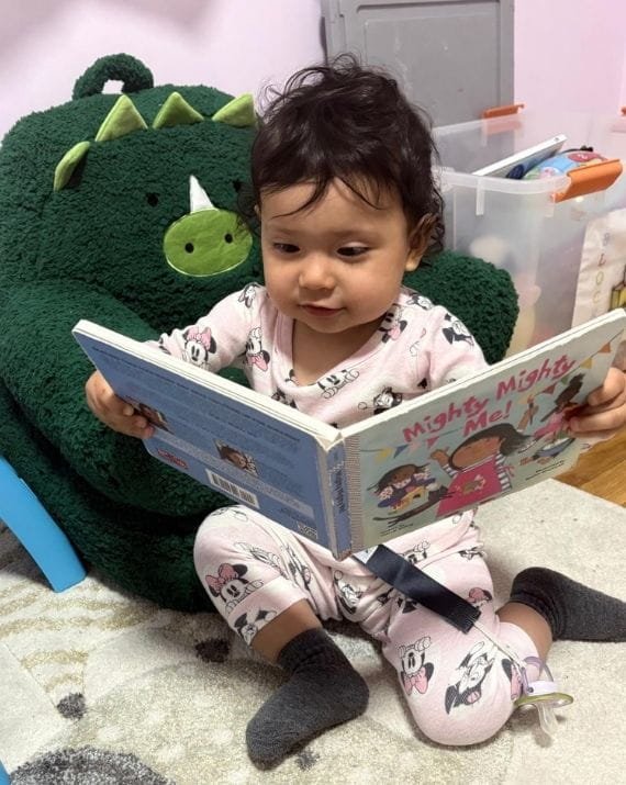 Child reading a book at Sweet Angels Daycare
