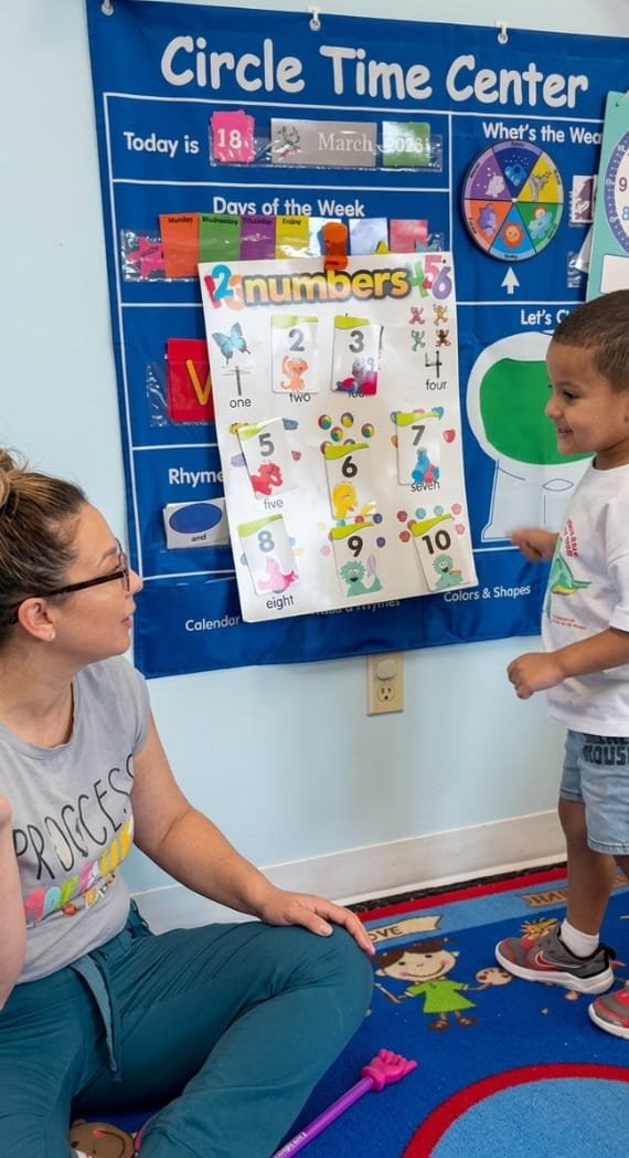 Teacher guiding a child during Circle Time at Sweet Angels Daycare & Preschool Center