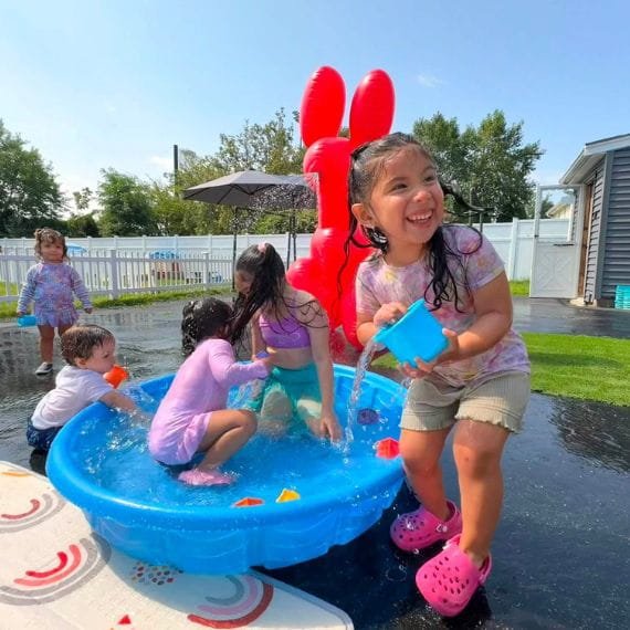 Preschool children enjoying outdoor water play at Sweet Angels Daycare & Preschool Center