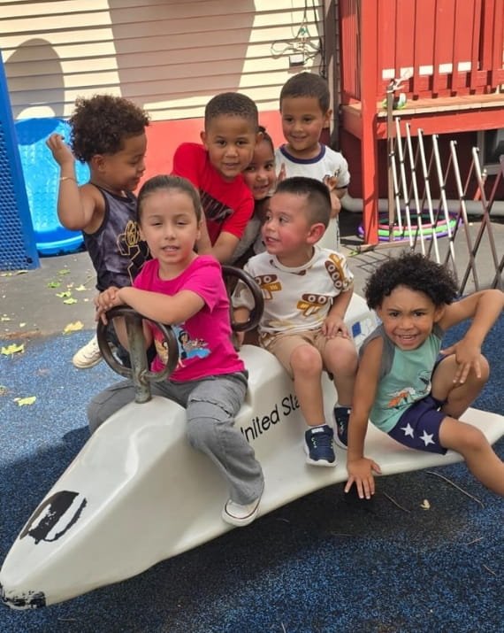 Children playing together on the playground at Sweet Angels Daycare in Everett, MA