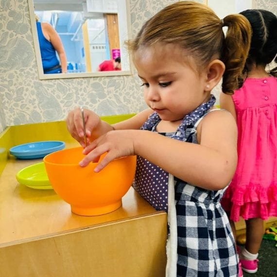 Child exploring materials during a sensory play activity at Sweet Angels