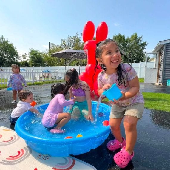 Children enjoying outdoor water play at Sweet Angels Daycare & Preschool Center